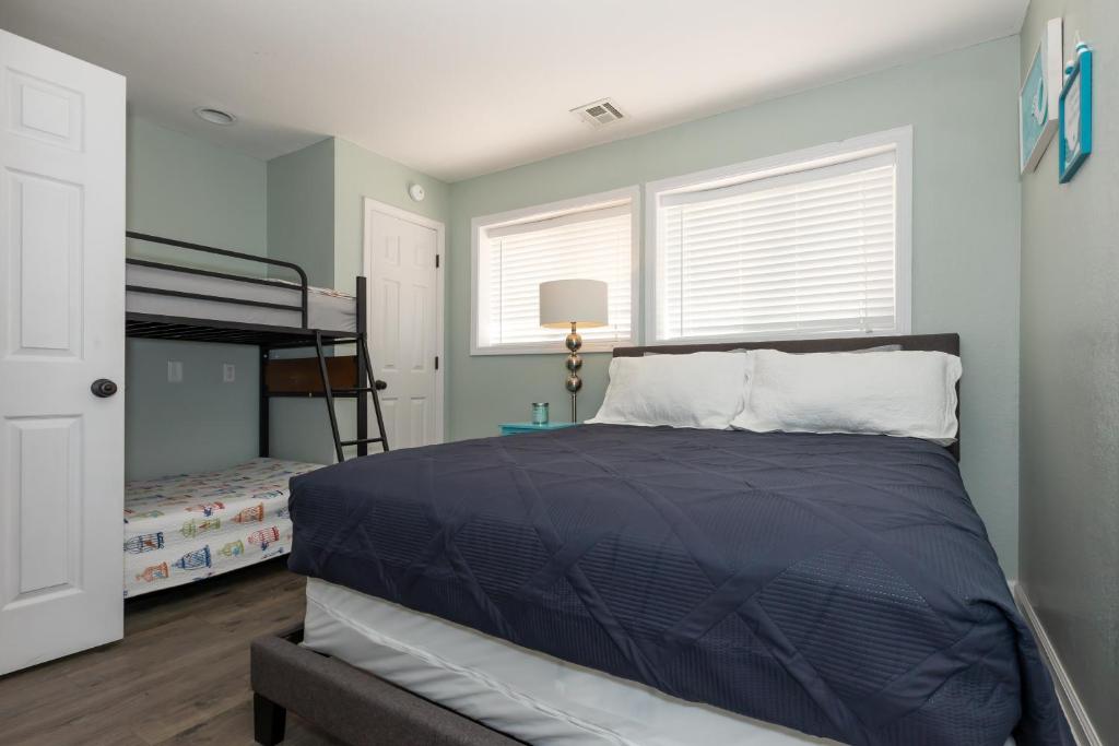 a bedroom with a bed with a blue comforter at Pet-Friendly Condo at MM-19 w/ Boat Slip & Lake Views in Laguna Beach