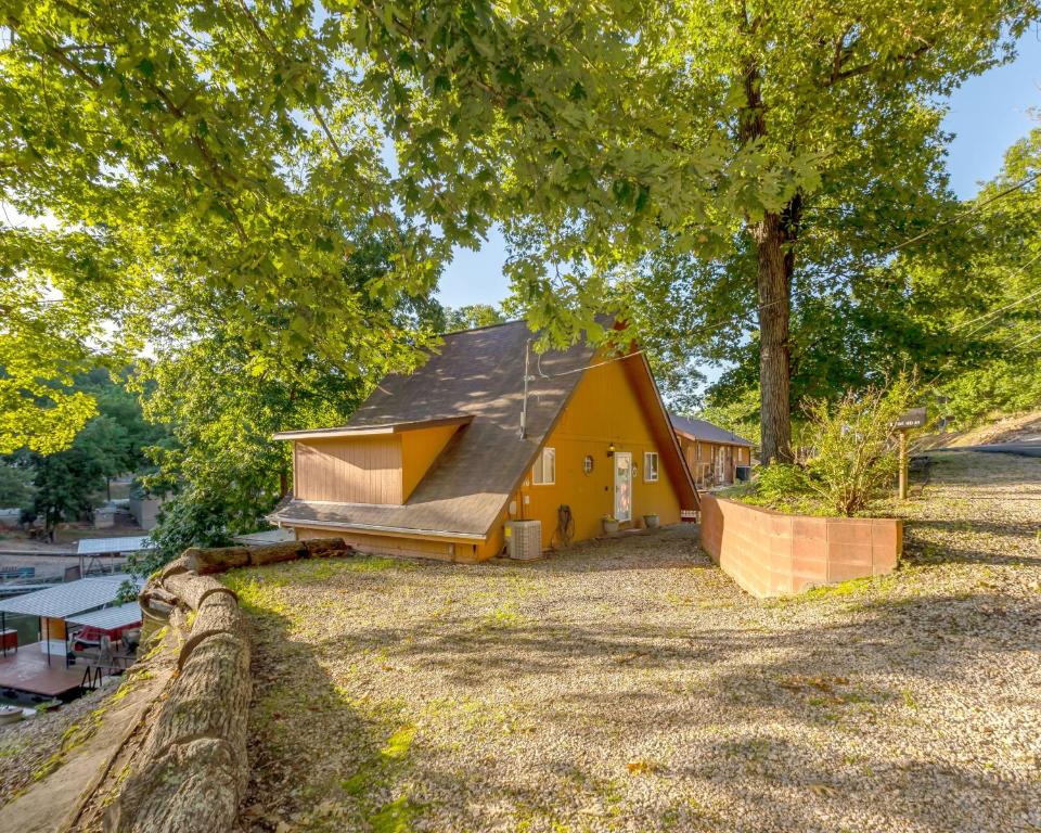 a small yellow house sitting on top of a field at Quiet Cove, Lake Views, Grill, Private Dock in Purvis