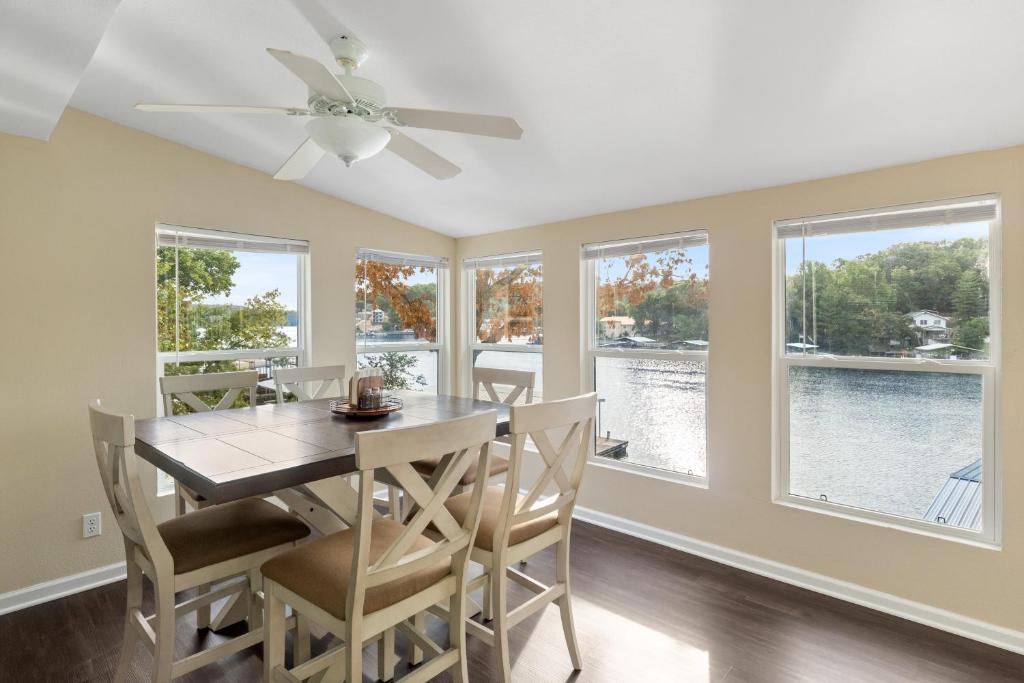 ein Esszimmer mit einem Deckenventilator und Fenstern in der Unterkunft Pet-Friendly Home, Great Dock, Waterfront, Lake Views, Boat Slip in Damsel