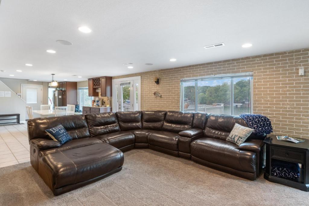 un soggiorno con divano in pelle marrone di Lake Life: Amazing Weekday Specials! Dock, Swim Mat, Cove Water a Rocky Mount