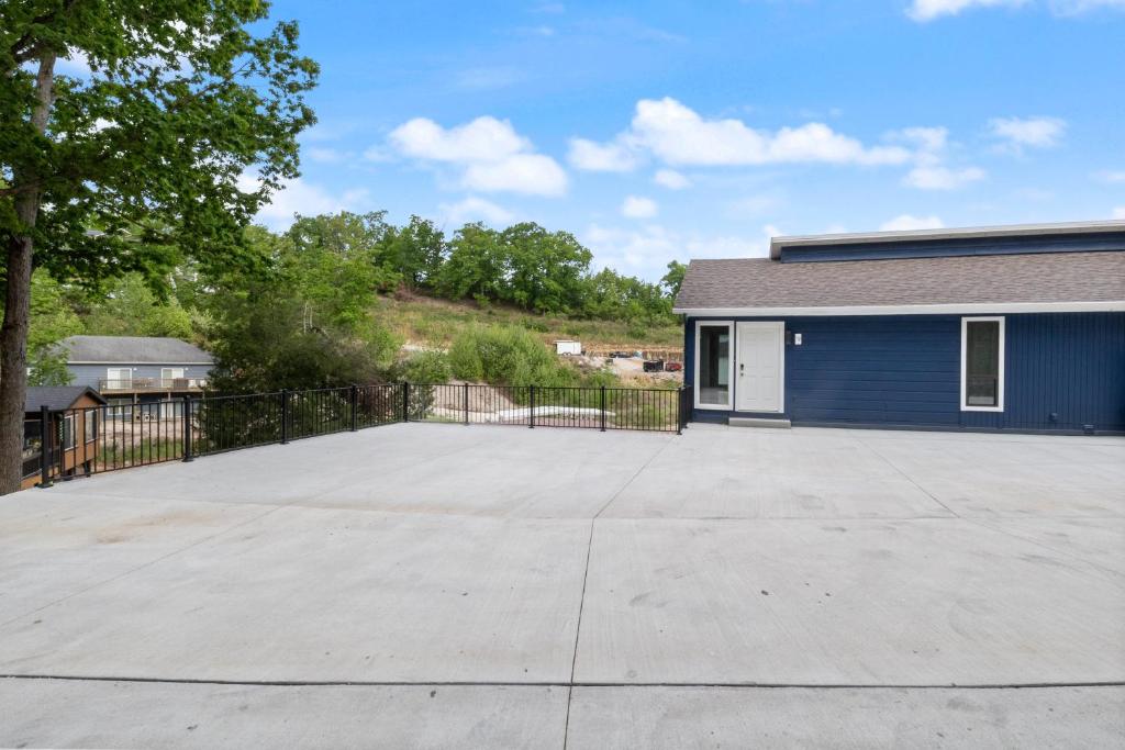 奥沙克湖Our Cove Retreat - Perfect for Wave-Free Swimming, Tanning & Prime Location Fun!的一栋蓝色建筑前的一个大型停车场