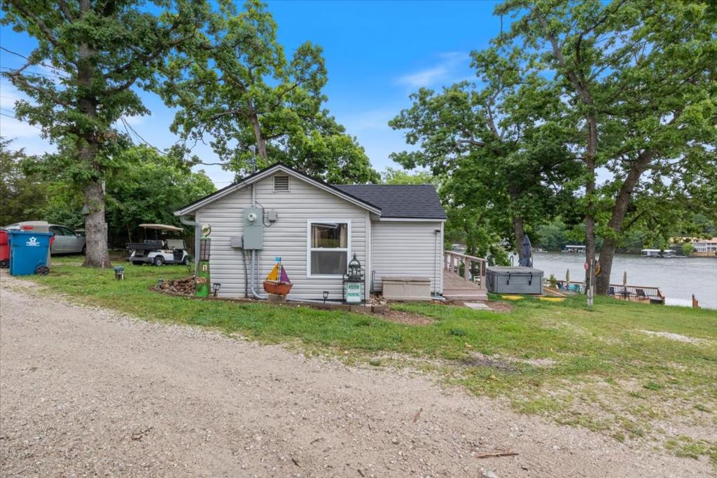 ein kleines Haus am Straßenrand in der Unterkunft Lakefront Fishing Retreat w/ Dock, Hot Tub & Deck Views in Sunrise Beach