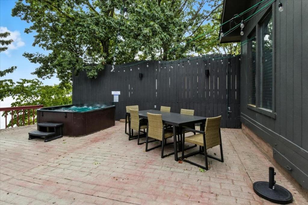 een patio met een tafel en stoelen en een hot tub bij Hot Tub, Main Channel Views, Great Outdoor Spaces, Blackstone in Sunrise Beach