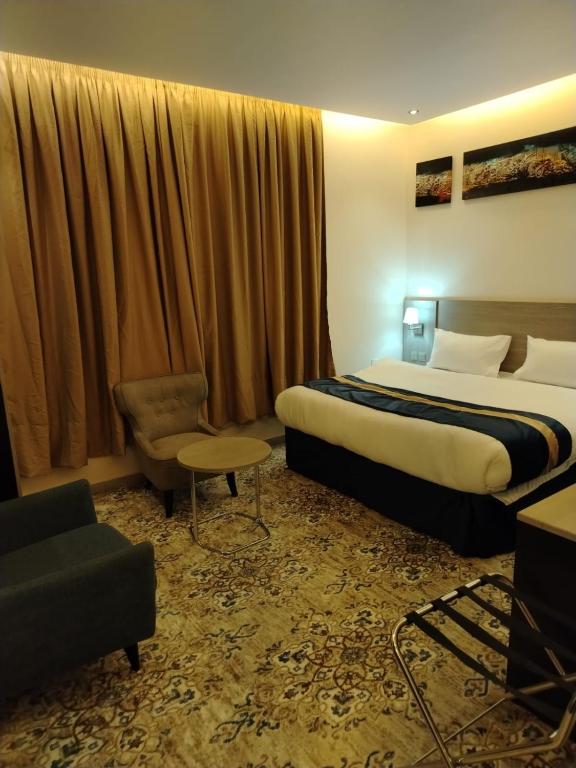 a hotel room with a bed and a chair at شقق المحمدية - Al Mohammadia apartment in Jeddah