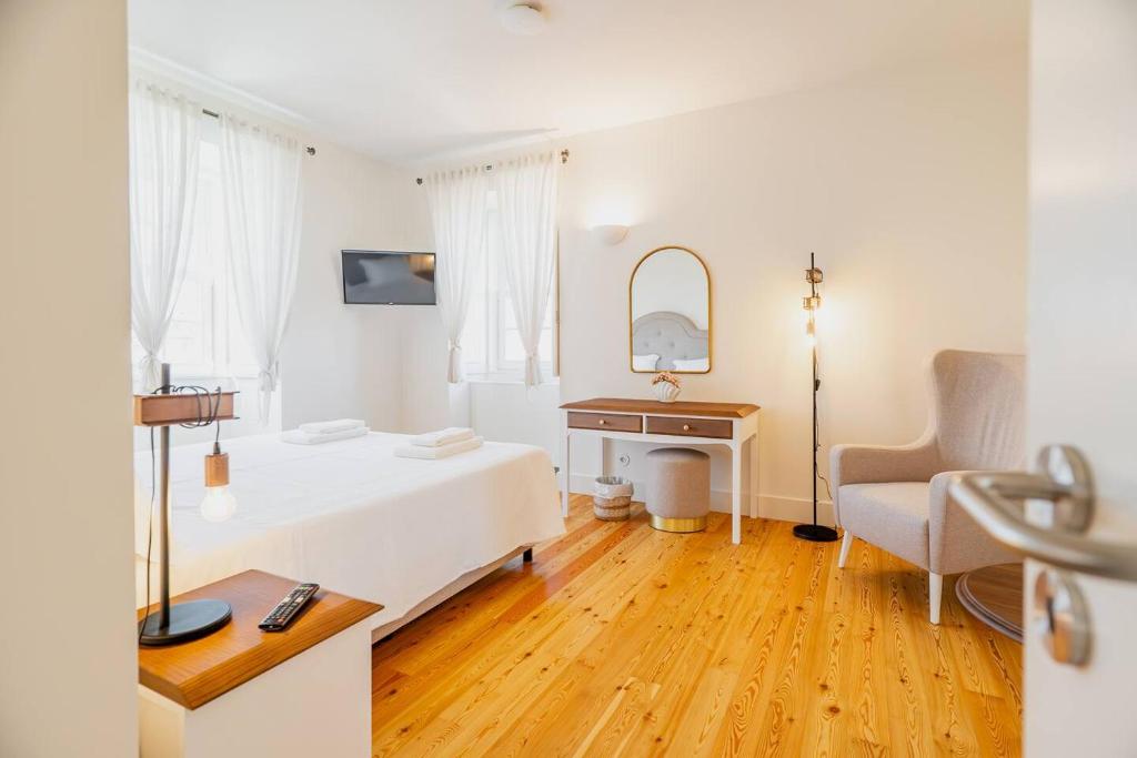 a bedroom with a bed and a desk and a chair at Private Villas & Boutique Hotel - Casa Da Brêa in Viana do Castelo