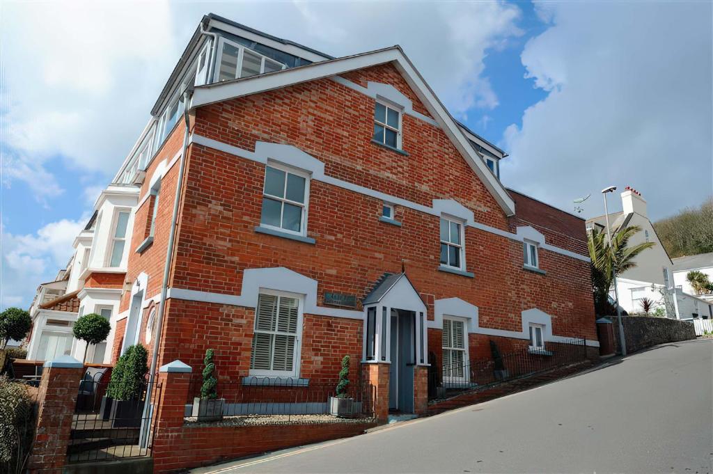 a red brick house with white trim on a street at Seaside in Lyme Regis