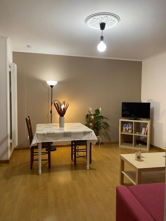 a living room with a table and chairs and a tv at Duplex appartement in Bayeux in Bayeux