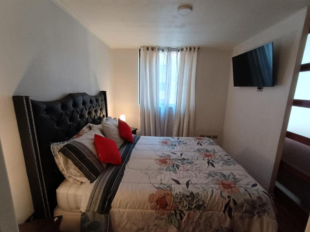 a bedroom with a bed with pillows on it at Danyedi Apart in Santiago