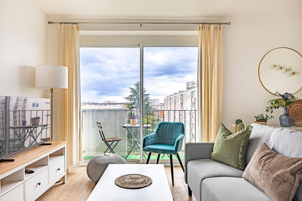 a living room with a couch and a large window at Friendly and spacious apartment in Créteil ! in Créteil