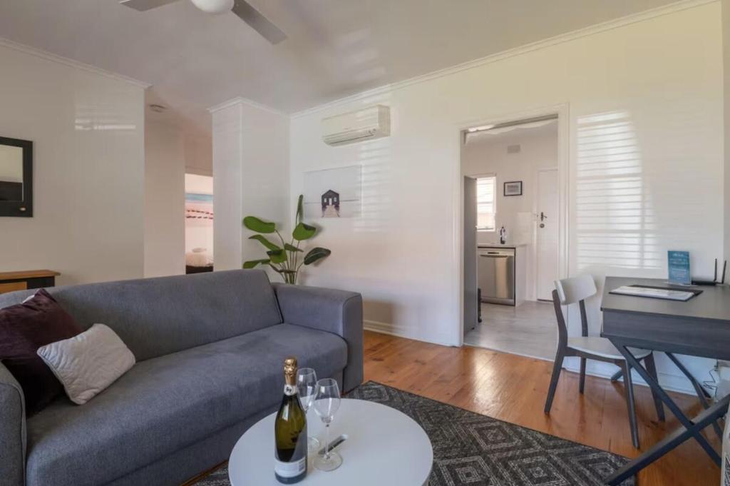 a living room with a couch and a table at Gem Apartment 4 - Courtyard I Beach I Wifi I Cafes in Glenelg