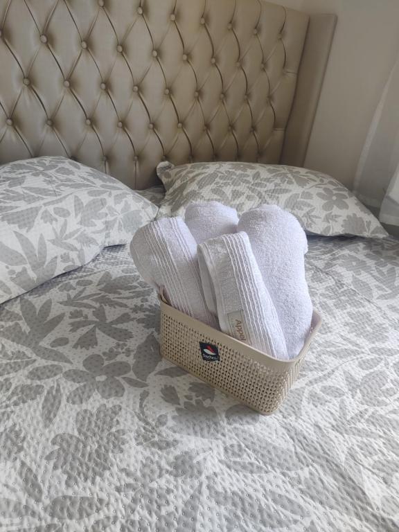a basket of towels sitting on a bed at Cantinho Real in Ilhéus