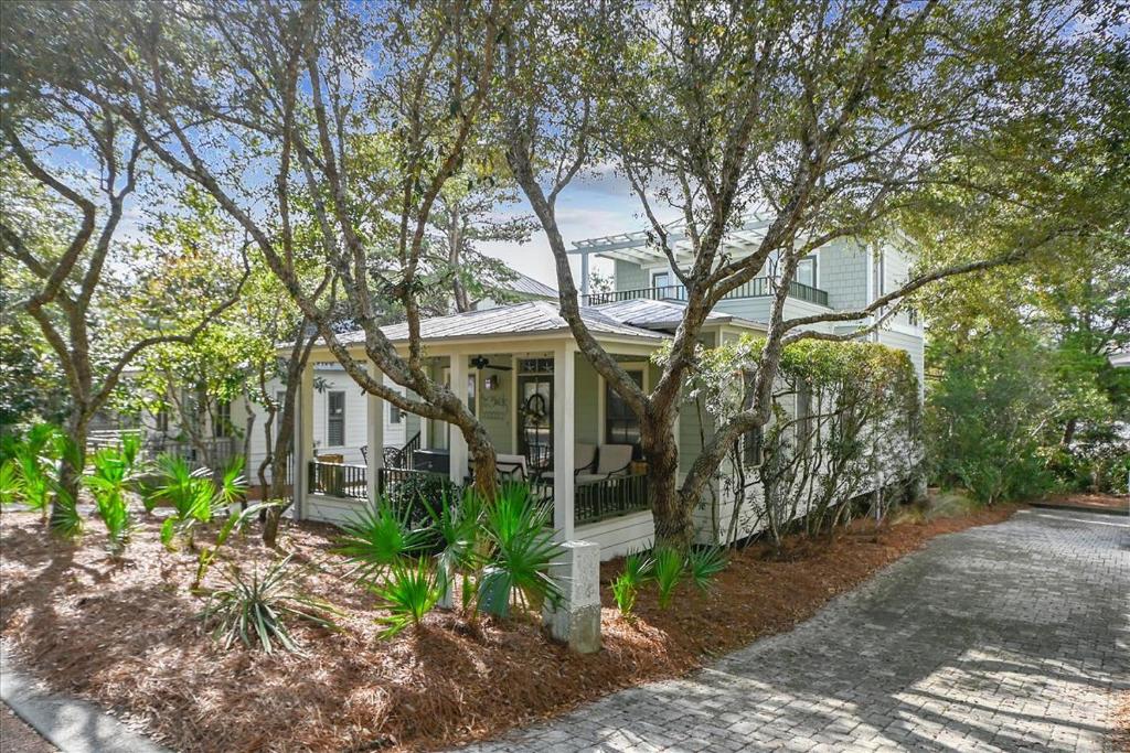 a white house with trees in front of it at Sans Souci by 30A Escapes in Seacrest
