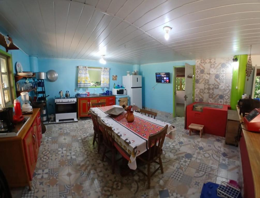a kitchen with a table in the middle of a room at Canto da Cachoeira relaxe ao som das águas in Tijucas