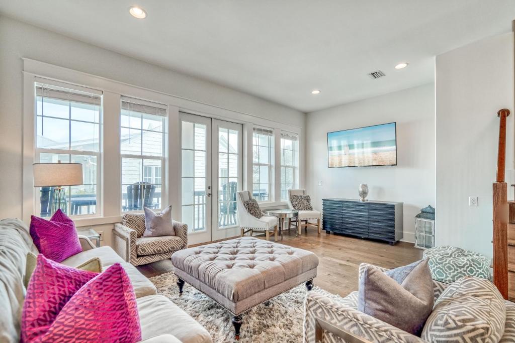 salon z kanapą, krzesłami i oknami w obiekcie Sandy Toes by 30A Escapes w mieście Rosemary Beach