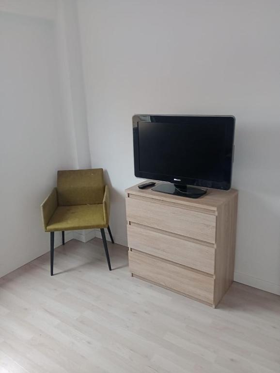 a chair and a television on a wooden dresser at Alojamiento K&A in Torrent