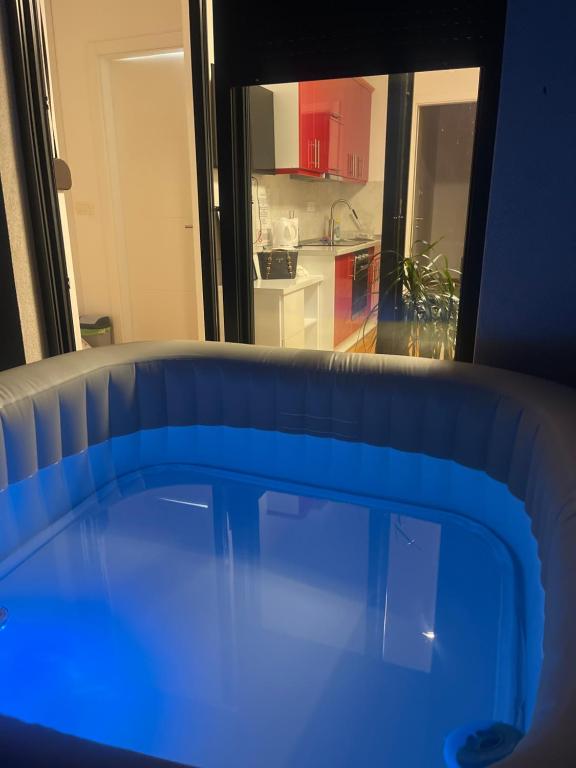 a blue tub in a room with a kitchen at Apartment Jacuzzi Mostar in Mostar