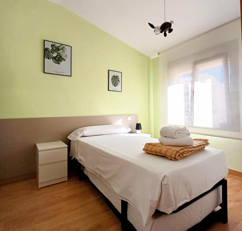 モンソンにあるÁtico en Monzónのベッドルーム1室(白いシーツとタオル付きのベッド1台付)