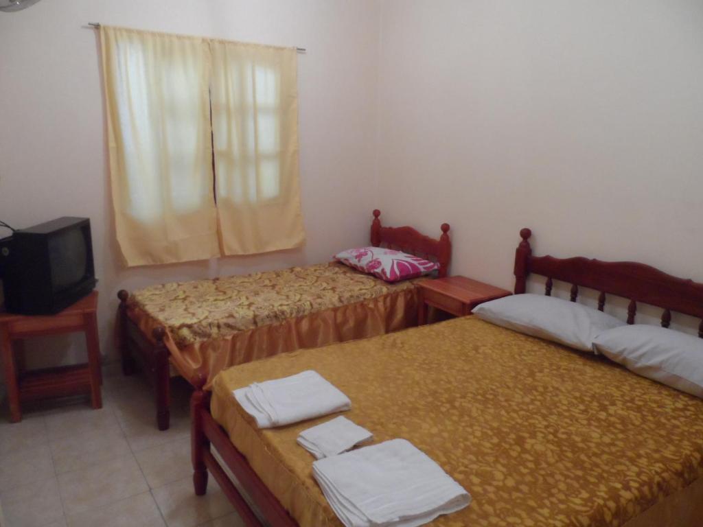 una camera con tre letti e una televisione di Alquiler Temporario Salta a Salta