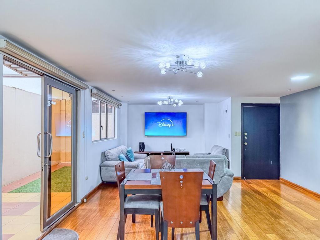 un soggiorno con un tavolo e un divano di Emerald Retreat con Jacuzzi y BBQ a Cuenca