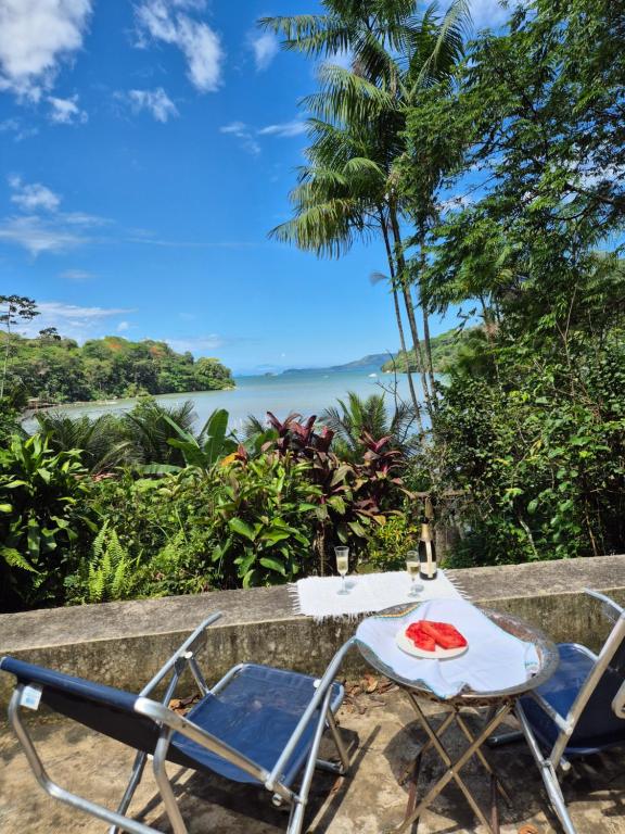 Una mesa y sillas con vista al mar. en casa vista linda, en Paraty