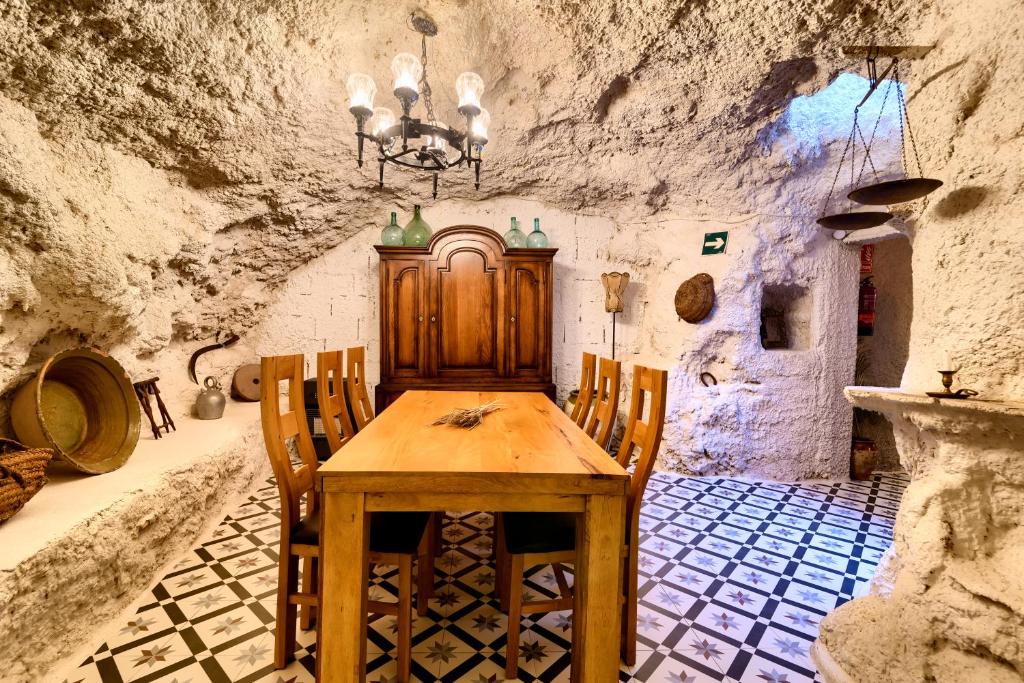 BenaguacilにあるCueva con chimenea a 20 minutos de Valenciaの木製のテーブルと椅子のあるダイニングルーム