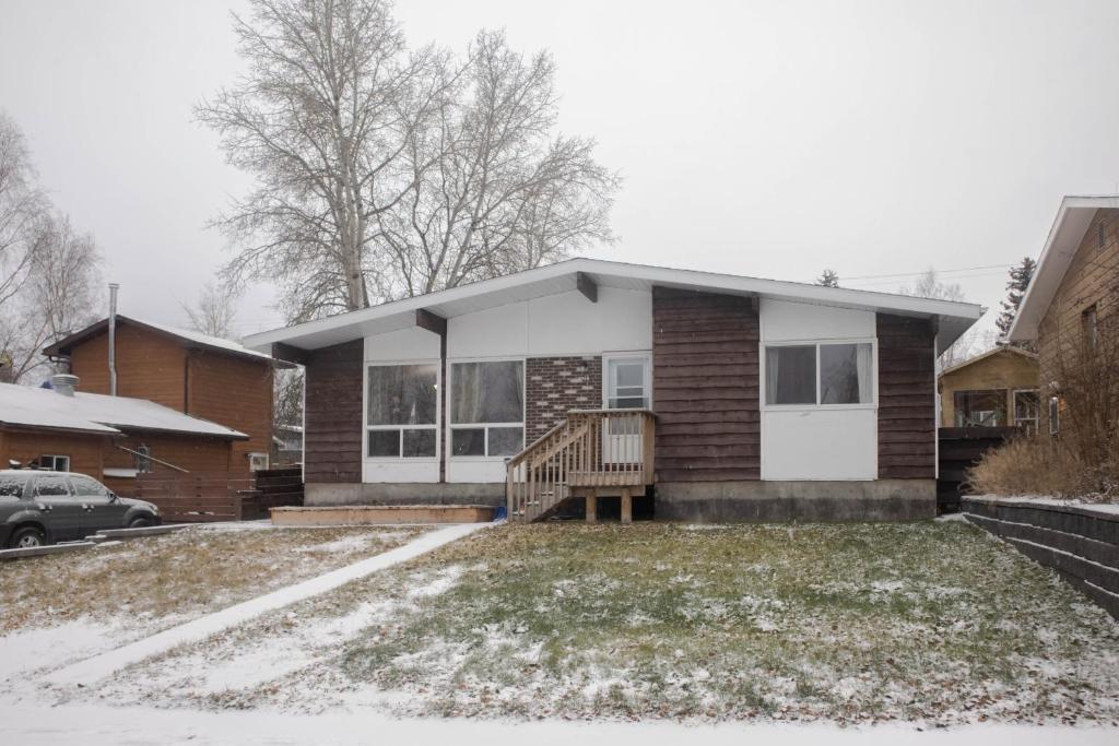 a house with snow on the lawn in front of it at Mi Light House 米拉 in Yellowknife