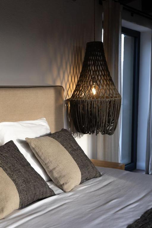 a bedroom with a bed with a chandelier above it at Mas Escarrà in Caldes de Malavella
