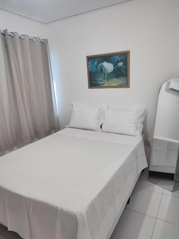 a white bed in a bedroom with a picture on the wall at STUDIO URBANO Ar Garagem 2 Quartos in Petrolina