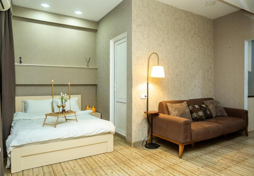 una camera da letto con un letto, un divano e un tavolo di Center Tbilisi Apartments a Tbilisi City
