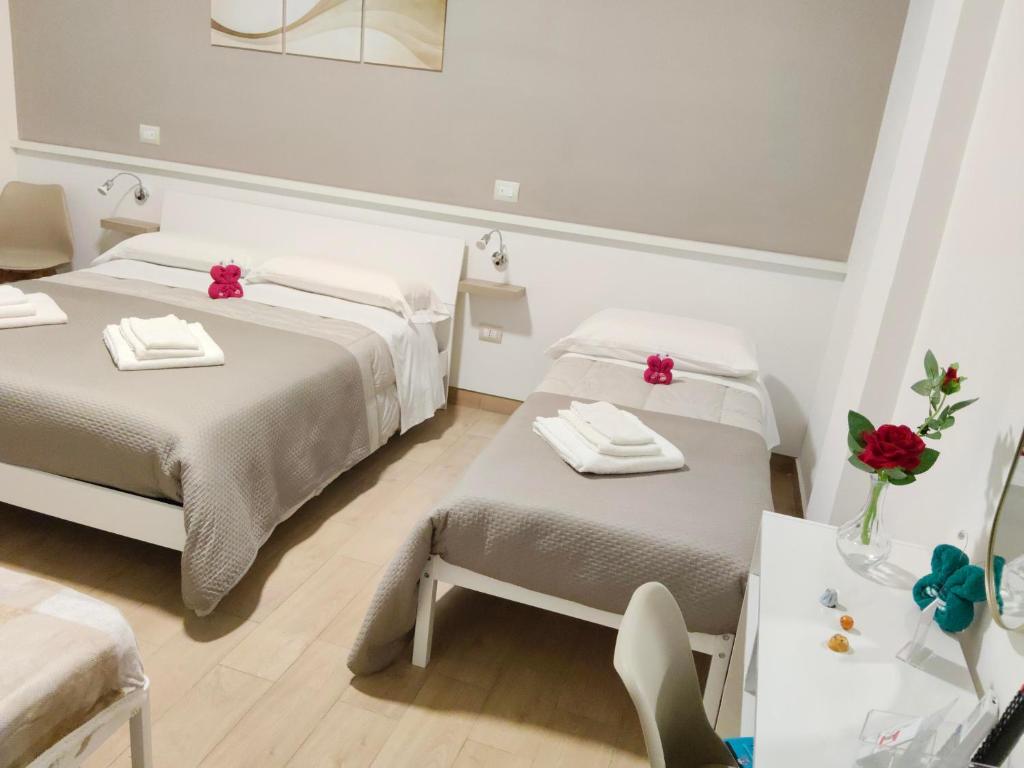 サンタ・マリーア・カープア・ヴェーテレにあるB&B Alle porte del centroのベッド2台とテーブルと椅子のある部屋