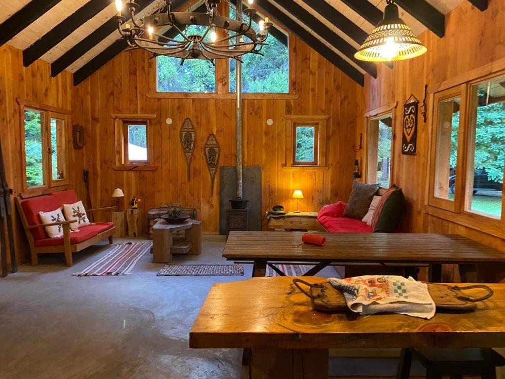un salon avec des murs en bois et des tables en bois dans l'établissement Casa Don Enrique Quila Quina, à San Martín de los Andes