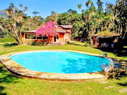 a swimming pool in the yard of a house at Pousada dos Chalés - Araras in Araras Petropolis