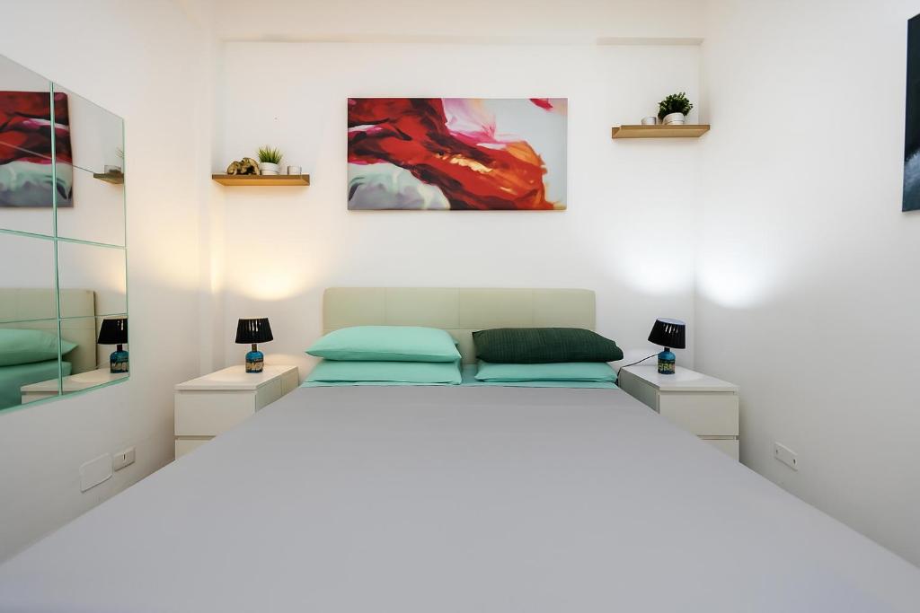 丽都迪奥斯蒂亚Lotus - Appartamento sul Mare a Ostia con Giardino Relax的一间白色卧室,配有床和2个床头柜