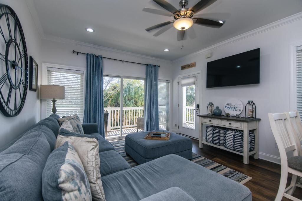 Una sala de estar con un sofá azul y un televisor. en Retreat 7B - Jubilee, en Edisto
