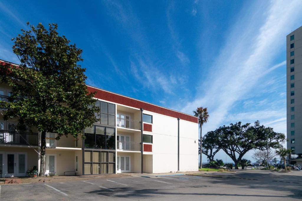 a large white building with a tree in front of it at Cozy 2 bed 2 bath condo at the beachside Ocean Club Villas in Beauvoir