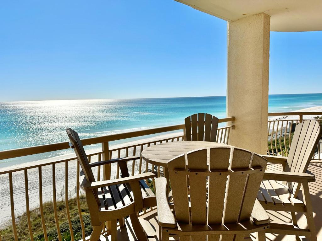 HP 36W Condo by 30A Escapes في روزماري بيتش: طاولة وكراسي تجلس على شرفة تطل على المحيط