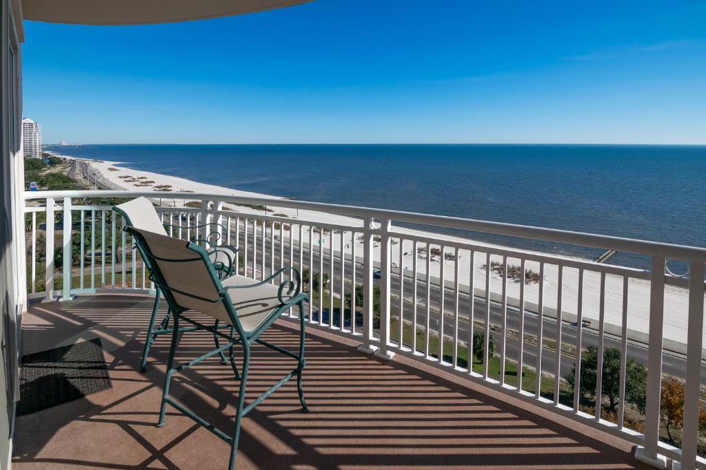 une chaise installée sur un balcon donnant sur la plage dans l'établissement Beachview Condo in Legacy Tower 1 -1104 - fully furnished 2 bedroom 2 bath, à De Buys