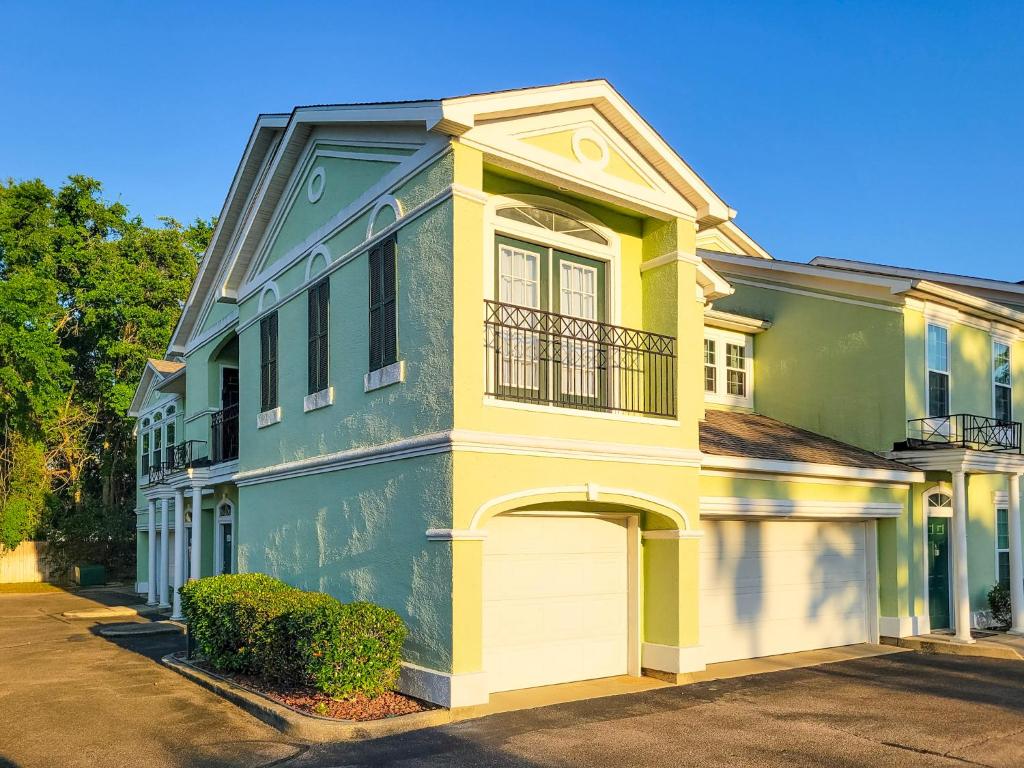 une maison verte et jaune avec un garage blanc dans l'établissement Legacy Villa 1103 - 1 bedroom 1 bath with garage in beachside neighborhood, à De Buys