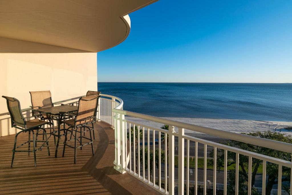 a balcony with a table and chairs and the ocean at Beachview Condo at Legacy Tower 2 -706 - fully furnished 2 bedroom 2 bathroom in De Buys