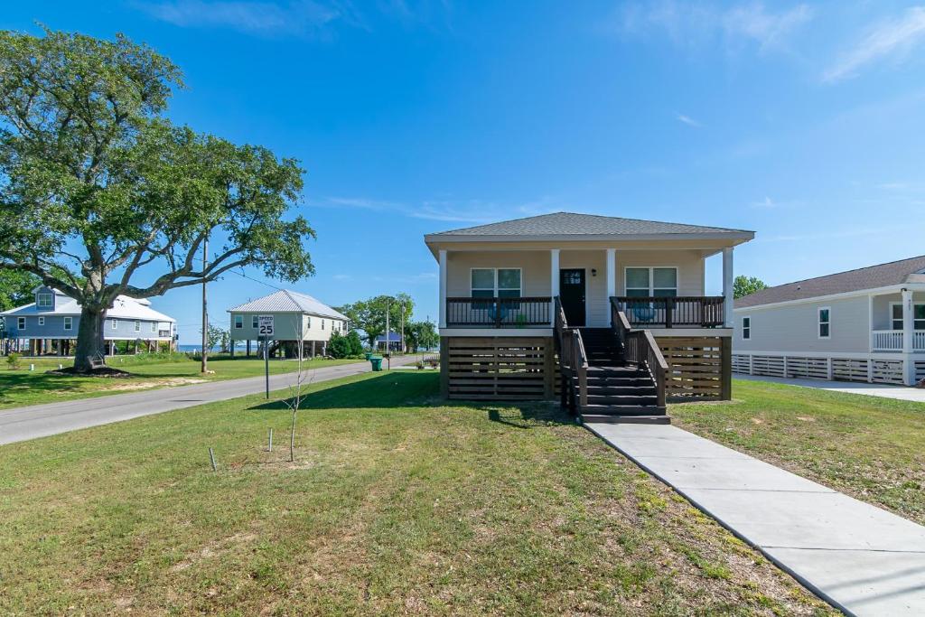 a house with a front porch with a driveway at Brand New Home with Beach Views! Fully furnished 3 bedroom home in Gulfport in Gulfport