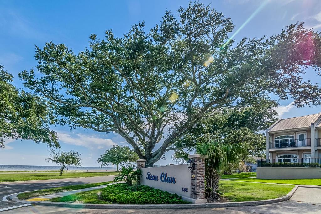 a tree with a sign in front of a building at 123 Beau Clair - Beachside Townhome with Balcony and Pool in Long Beach in Long Beach