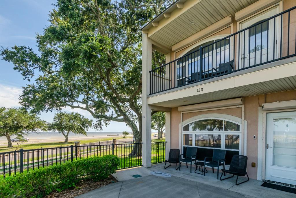 a house with a porch with chairs and a balcony at 120 Beau Clair - Beachview Townhome with Balcony and Deck in Long Beach in Long Beach
