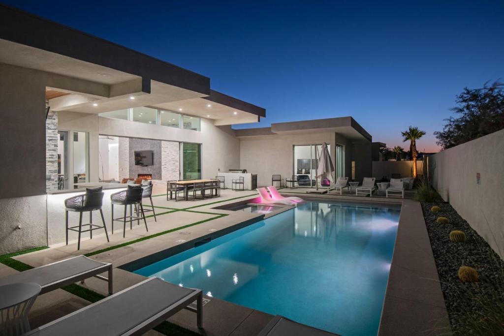 a house with a swimming pool in front of it at Krypton @ Elemento49 Pool Spa Sleeps 16 in Desert Groves Mobile Home Park