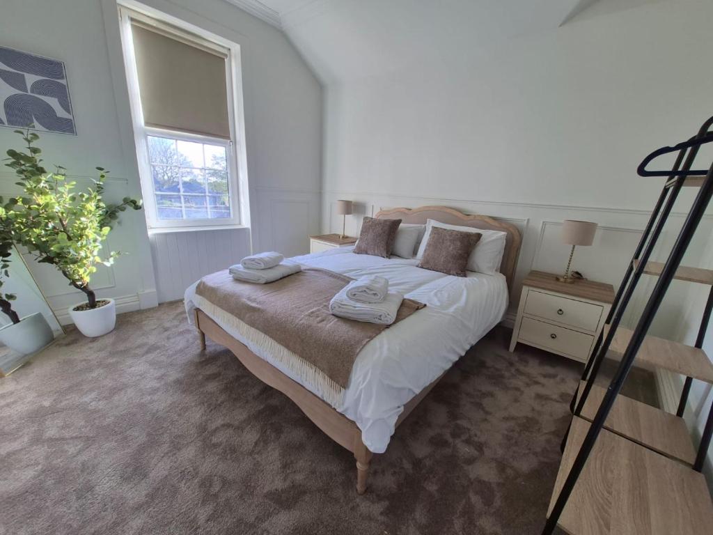 een slaapkamer met een bed met handdoeken erop bij Kirkgate 2 bed - Coorie Doon Stays in Irvine