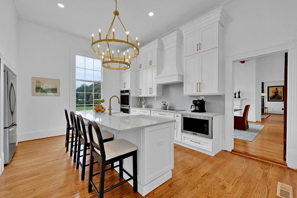 a kitchen with white cabinets and a table with chairs at Eighty Oaks, Jacksonville, AL in Jacksonville
