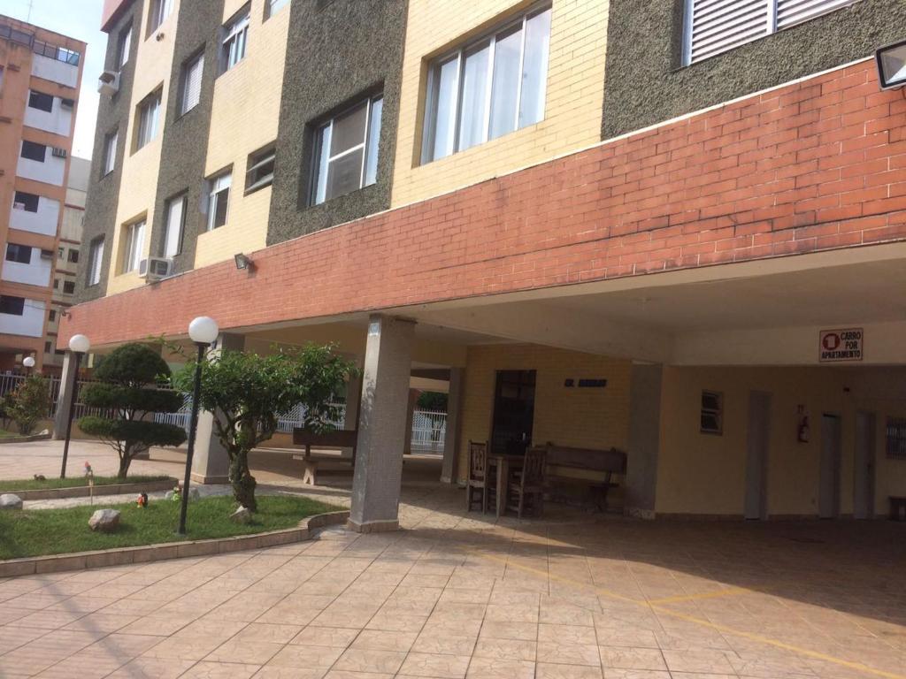 ein großes Backsteingebäude mit einem Innenhof davor in der Unterkunft Apartamento temporada Guarujá in Guarujá