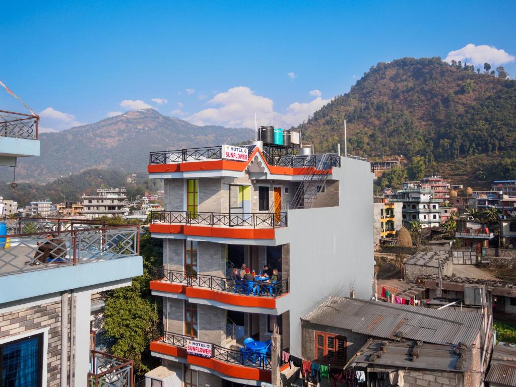 un edificio con balconi e una montagna sullo sfondo di Hotel Sunflower a Pokhara