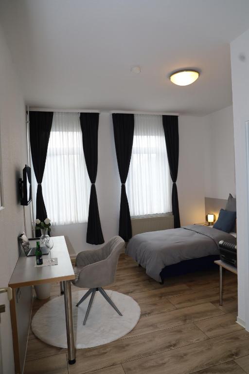 um quarto com uma cama, uma mesa e uma escrivaninha em Hotel Mutter Buermann em Hemmingen