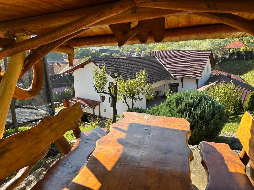 a wooden bench in a yard with a house at Pensiunea Hanzu Darius in Gura Rîului