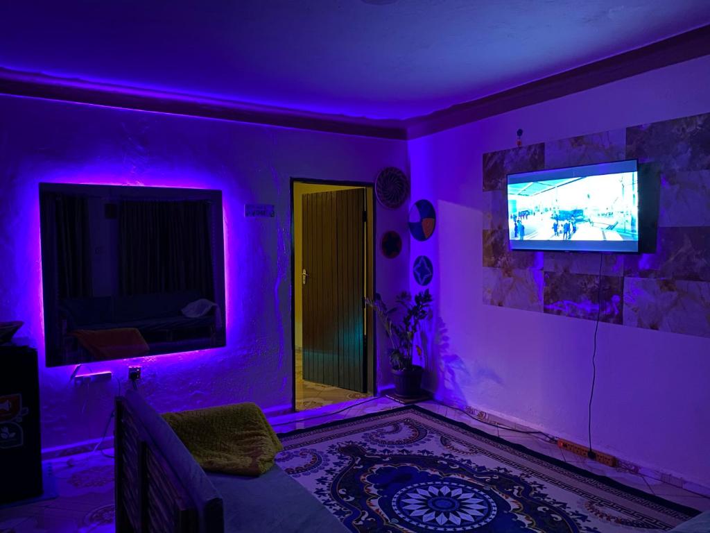 ジンジャにあるLa Jinjaの紫色の照明とテレビ付きのリビングルーム